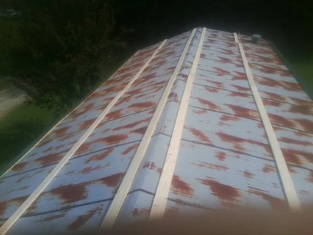 Rusted metal roof panels with new wood purlins before replacement — Storm Damage Roof Repair in Chelsea by Roofing Brothers